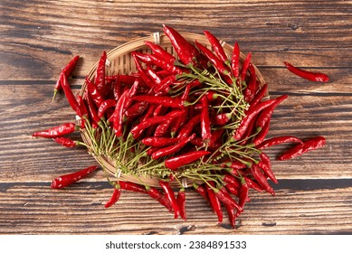 A bunch of ripe red hot chili peppers on wooden table.