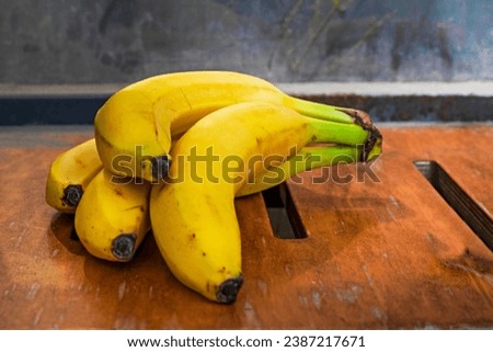bunch of ripe yellow banana on a wooden surface.