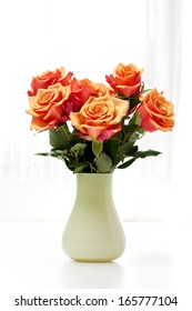 A Bunch Of Roses In A Green Vase