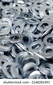 Bunch Of Stainless Steel Galvanized Flat Washers For Fastener Screws, Nuts Or Bolts, Hardware Background. Stack Of Flat Washers For Distribute Load Of Threaded Fastener, Close Up