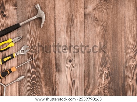Bunch of tools placed on the left of a wooden table, captured from above.