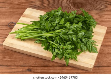 Bunch of the twigs of fresh parsley on a wooden cutting board on an old rustic table
 - Powered by Shutterstock