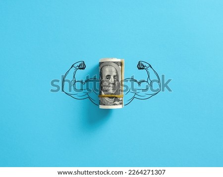 Bunch of United States dollar money with flexing muscle biceps on blue background. Strong or highest currency concept.