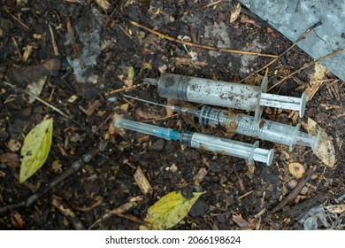 bunch of used dirty syringe leaved after drug injection lying on ground outdoor