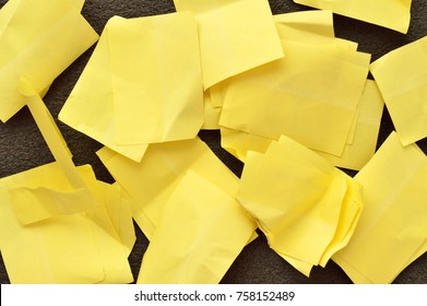 A bunch of used sticky notes over a black surface