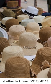 Bunch of various straw hats and fedoras placed on stall on summer day on street market - Shutterstock ID 2246358467
