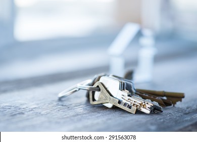 A Bunch Of Vintage Keys With Metal House On The Wooden Table