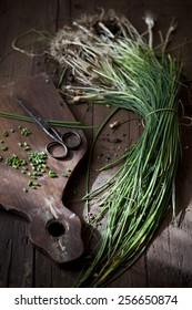 Bunch Of Wild Chives With Roots On Wooden Table With Natural Sunbeam