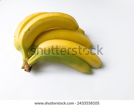 Bunch of yellow bananas with one small green banana on white background
