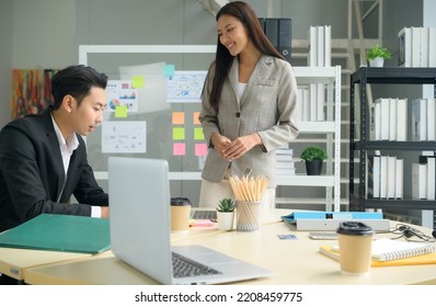 A Bunch Of Young Asian Businesspeople. Meeting In A Room With Windows For Natural Light To Discuss Stock Investing Data.