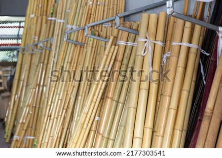 Bunches of bamboo poles in gardening shop or storage house.