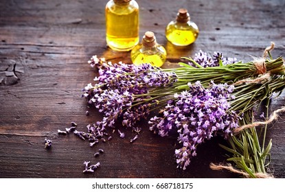 Bunches Of Fresh Lavender With Three Small Bottles Of Essential Oil Or Extract For Aromatherapy Or Alternative Medicine Lying On Rustic Wood With Copy Space