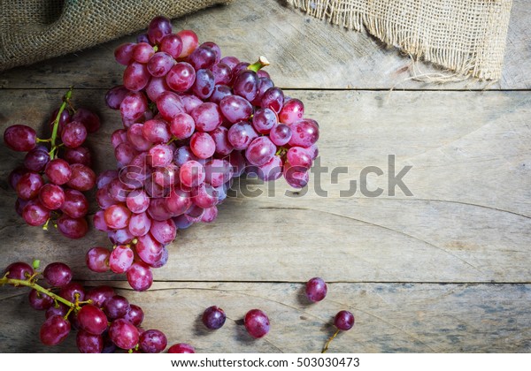 木のテクスチャー面に 新鮮な熟した赤いブドウの房 美しい背景に青いブドウの枝が付いた古いスタイル 赤ワインのブドウ 暗い葡萄 青い葡萄 ワインブドウ の写真素材 今すぐ編集