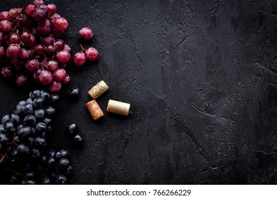Bunches of red and black grape on black background top view copyspace