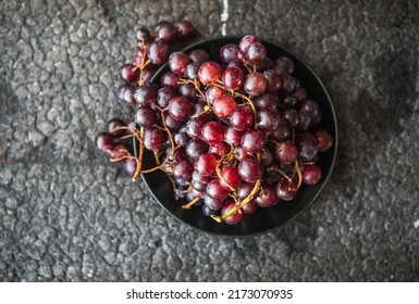 Bunches Of Red Grapes On Old Black  Wooden Table . Symbol Of Autumn Cornucopia, Top View