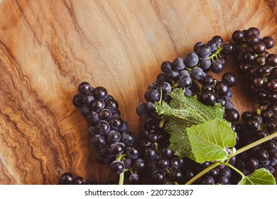 Bunches Of Ripe Grapes With A Grapevine On A Teal Wood Background With Copy Space