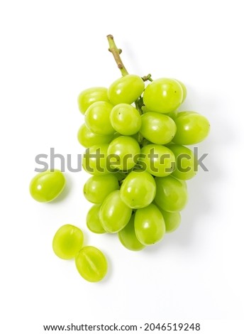 Bunches of Shine-Muscat grapes and cut Shine-Muscat grapes on a white background. White grapes. Japanese grapes. View from above.