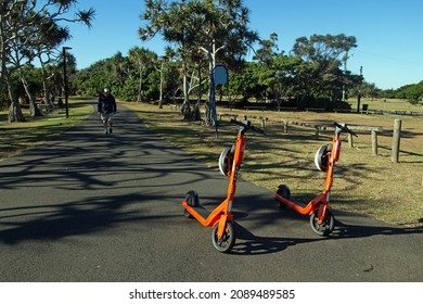 Bundaberg, Queensland, Australia, June 5 2021.Electric Scooters Parked At Schuhcraft Park At Bargara. A Middle Aged Man Walking Toward The Camera On A Sunny Day.