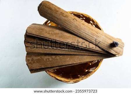 Bundle of ancient palm leaves dried palm leaf for manuscripts in wooden and green background, its used as writing material in ancient times, blank dried palm leaf with text space. top view,side view