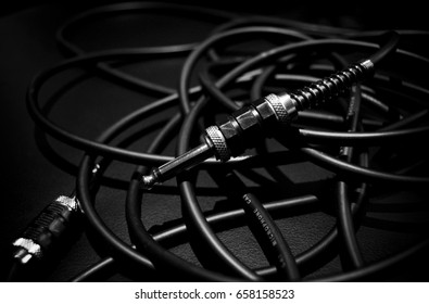A bundle of audio cables on an amplifier, black and white photo.