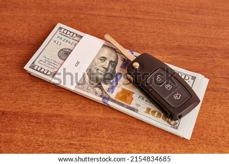 Bundle of dollars with the inscription car and car keys. Car buying concept.
