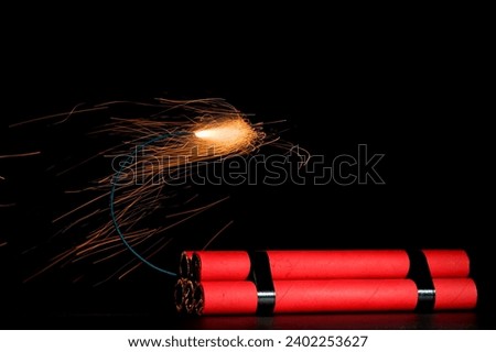 A bundle of dynamite with lit fuse again black background