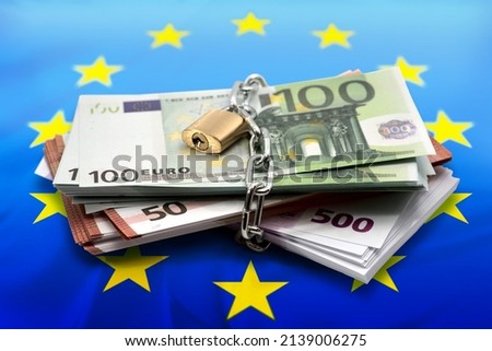 Bundle of euro bill, lock, chain, EU flag. Concept with European Union money, cash, loans, mortgage.