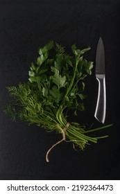 bundle of greens and a knife isolated on black background flat lay. Image contains copy space - Shutterstock ID 2192364473