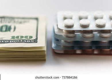 Bundle of money and  pack of medication tablets or drug pills, close-up. Expensive health care concept, selective focus - Powered by Shutterstock