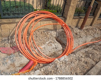 Bundle Orange Fiber Cable On A Construction Site. Building Of Lines Of Metallic And Fiber Optic Cables Of Communication Network Connection