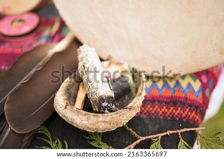 A bundle of sage and an eagle feather are laid out in preparation of a Native American, Indian, or Indigenous smudging ceremony.  Pemberton BC, Canada. 

