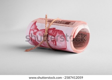 A bundle of Serbian dinar banknotes rolled up and isolated on a white background, a stack of 1000 dinar banknotes wrapped with twine.