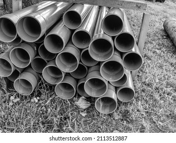 Bundles of blue plastic pipes for water transport. Pipe batch construction site. BW, Black and white,