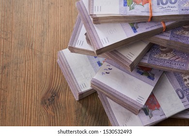 bundles of malaysia currency on the wooden table - Shutterstock ID 1530532493