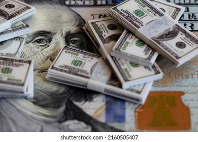 bundles of miniature 100 dollar banknotes on 100 dollar banknote background for design purpose - Shutterstock ID 2160505407