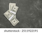 Bundles of one hundred dollar banknotes on black grunge background