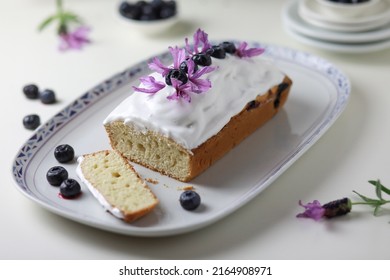 Bundt cake with glazing decorated with fresh blueberry fruits and lavander flowers. 