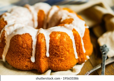 Bundt Cake With White Glaze On Rustic Background