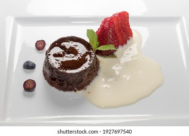 bunet pudding,traditional italian Piedmont dessert in white plate with strawberries and eggnog