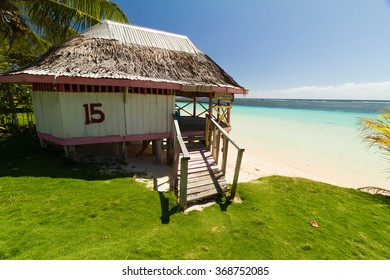 Bungalow On A Sunny White Sand Beach With Crystal Clear Blue Sea On South Pacific Island