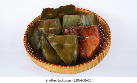 Bungkus Pisang - Banana Wrap. Traditional Wrap Method Using Banana Leaves, Sealed With A Stick. Placed On Plate Made Of Bamboo. High Angle View