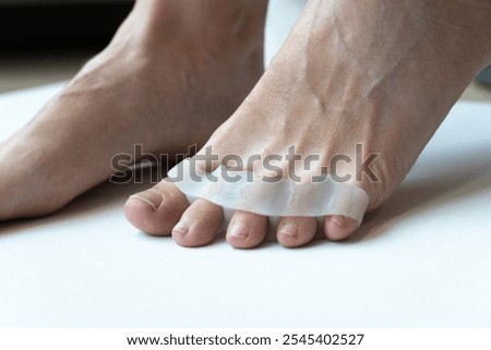 Bunion, hallux valgus. Silicone finger toe separator on feet isolated on white background. preparing for foot pedicure at home with nail separators