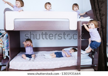Bunk bed for children. Many clone baby girls in child room in domestic life. identical child crowd. Kid with different emotion and playing everywhere