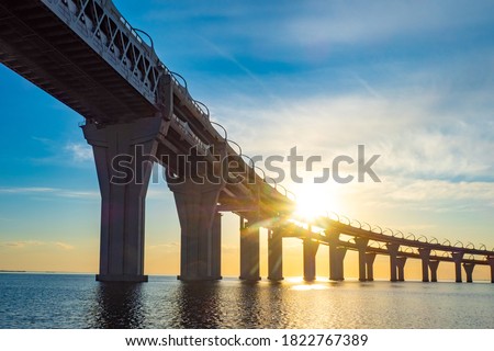 Bunk bridge at sunset background. Road bridge over bay. Concept is the construction of bridges. Bridge stands on large piers view from below. Bridgework for the movement of trains. Stock foto © 