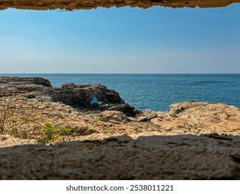 Bunker window framing view of rugged coastal landscape with rocky cliffs in Adriatic Mediterranean Sea. Travel destination Banjole on Istria peninsula, Kvarner Gulf, Croatia, Europe. Summer vacation - Powered by Shutterstock