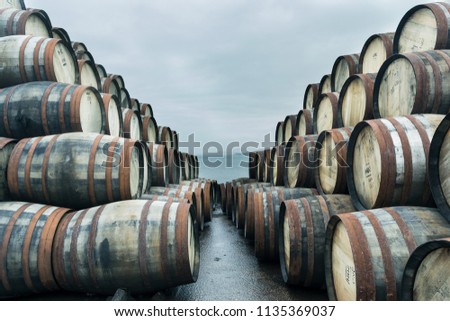 Bunnahabhain distillery, Islay, Scotland. Lots of weathered whisky casks are stacked up outside Bunnahabhain distillery Islay. Feb 2017