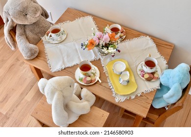 Bunny And Toy Stuffy Tea Party With Cookies And Fancy Dishes. 