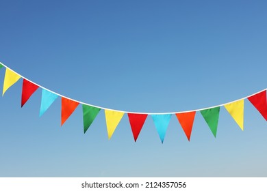 Bunting with colorful triangular flags against blue sky