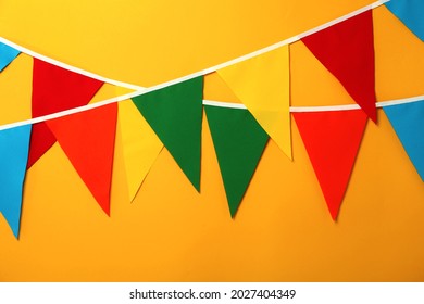 Buntings with colorful triangular flags on orange background - Shutterstock ID 2027404349