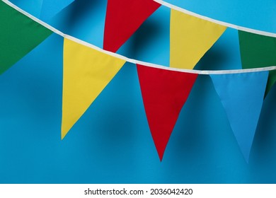 Buntings with colorful triangular flags on light blue background - Shutterstock ID 2036042420